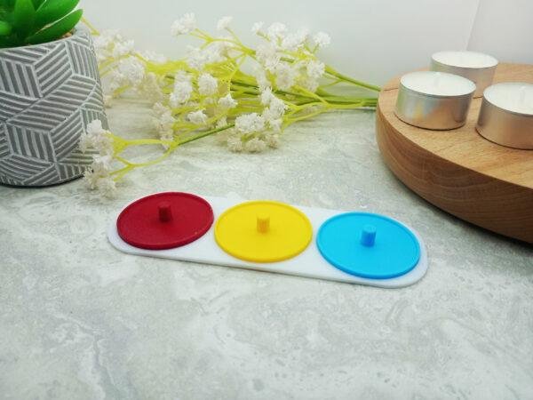 An image of the three person holder taken from vertically above. It includes the green, blue and red toothbrush holders connected by the white base piece. Each part is 3d printed to create a clean, modern piece that will suite most bathrooms. 3 person electric toothbrush stand. Available in different colours. Choose from green, blue, yellow, red and white.