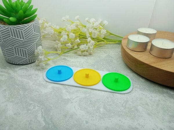 The photo shows a three person electric toothbrush holder suitable for use with Philips Sonicare toothbrushes. Each holder is printed in brightly coloured PLA of the buyers choosing and joined by a white base. The base is rectangular with curved corners. Each toothbrush holder has a small lip to help prevent driping. Three person electric toothbrush holders. Available in different colours. Choose from green, blue, yellow, red and white.