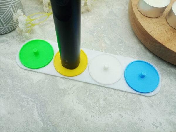 Four person electric toothbrush holder personalised in white, green, yellow and blue.