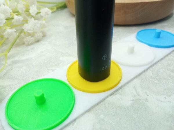 Four person electric toothbrush holder personalised in white, green, yellow and blue.