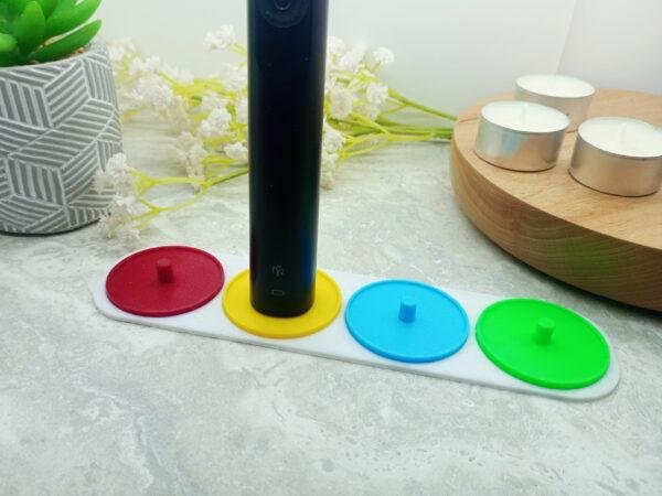 Four person electric toothbrush holder in red green, yellow and blue.