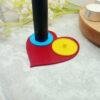 A romantic heart shaped toothbrush holder suitable for Philips toothbrushes. The image shows the red heart of the holder base with two bright circular holders of yellow and blue mounted on top. The two person heart shaped electric toothbrush holder is a modern, playful romantic gift for couples moving in together or as a fun romantic 'his and her' gift.